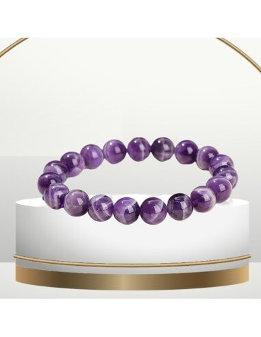 Un bracelet de perle d'amethyste sur un socle en marbre